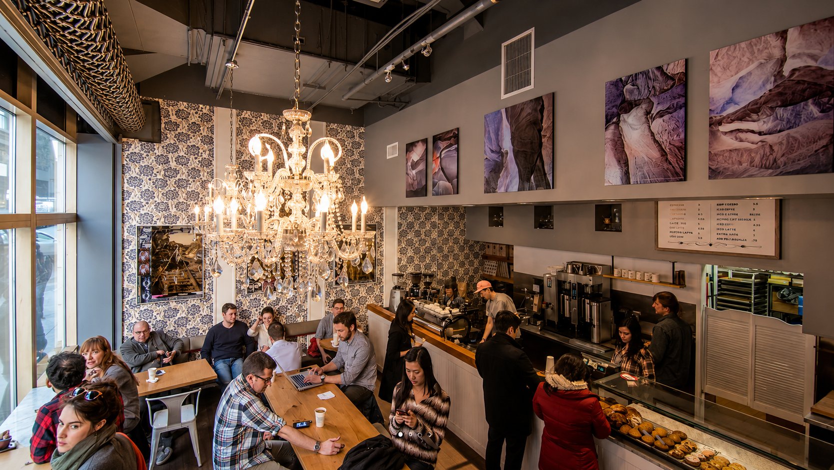Guests enjoying a lively café under a chandelier